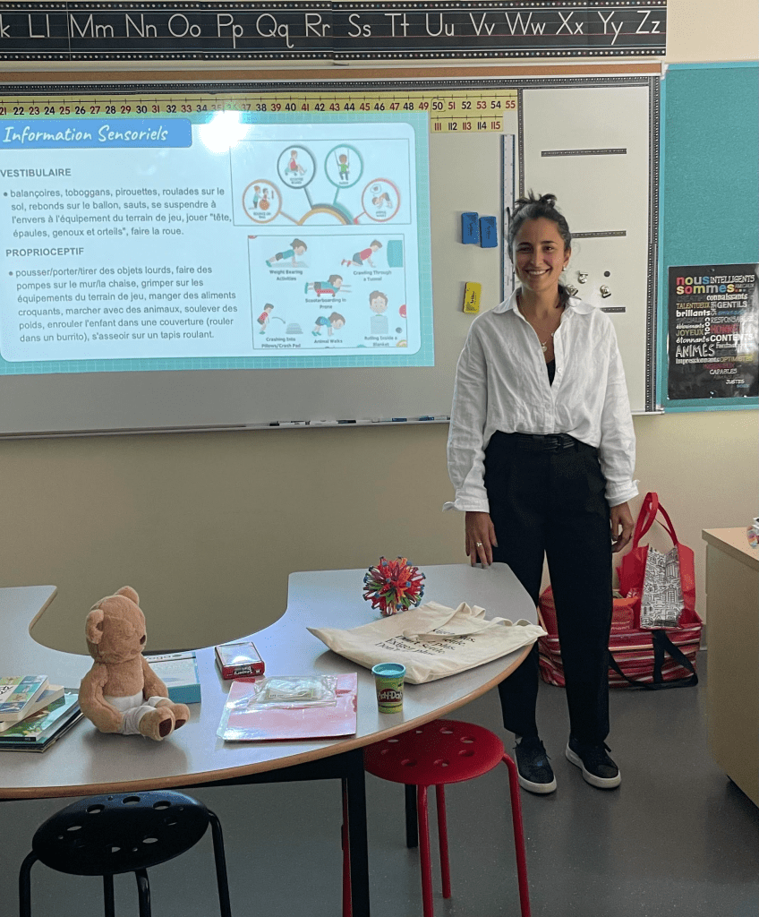 educational speaker standing next to a desk with a presentation on screen